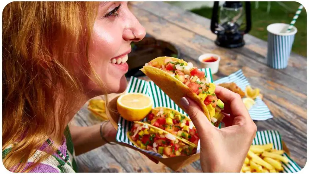 a person eating a taco on a picnic table