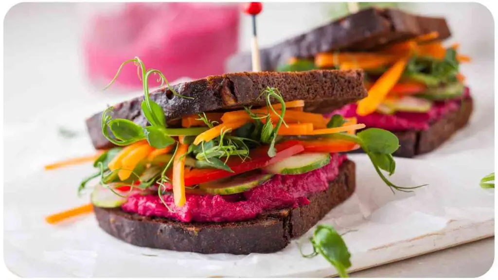 a sandwich with beetroot, carrots and cucumber on it