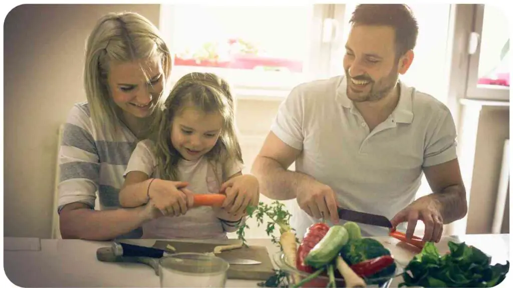 a person, person and child are cutting vegetables together