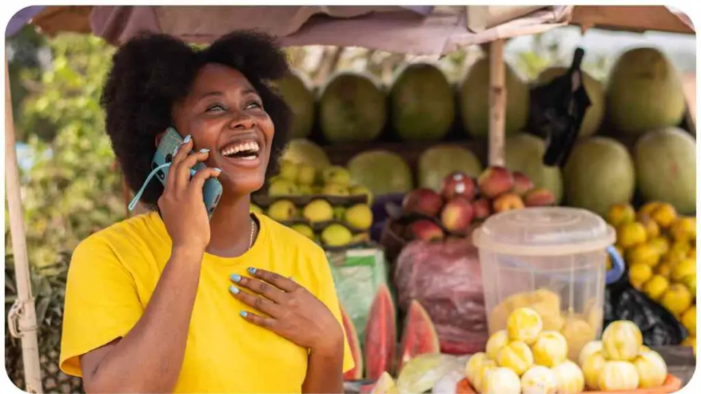 a person is talking on a cell phone while standing in front of a fruit stand